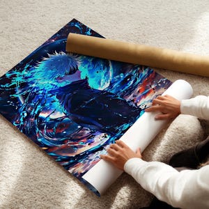 May include: A vibrant anime-style art print featuring a character with white hair and blue accents. The artwork is displayed on a soft, light-colored surface, with a rolled-up poster and a brown cardboard tube nearby.