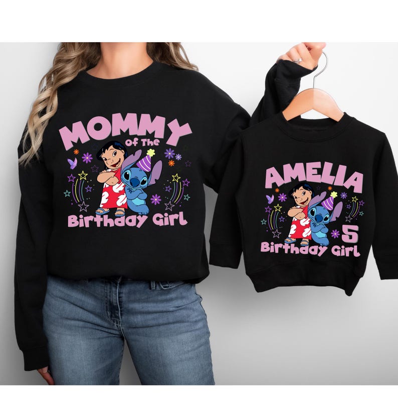 May include: Black sweatshirts with a graphic featuring Lilo and Stitch, text that reads "Mommy of the Birthday Girl" and "Amelia 5 Birthday Girl". The sweatshirts have a crew neck and long sleeves.