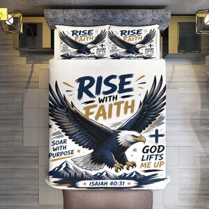 Könnte beinhalten: Weißes Bettwäsche-Set mit einem majestätischen Adler-Design. Der Aufdruck zeigt die Worte "RISE WITH FAITH", "SOAR WITH PURPOSE" und "GOD LIFTS ME UP". Das Set beinhaltet zwei Kissenbezüge und eine Bettdecke.