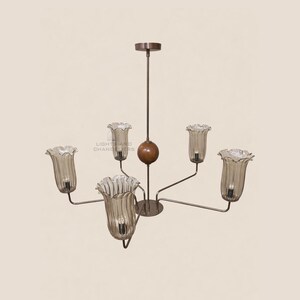 May include: A vintage-style chandelier with six light fixtures. The light fixtures are shaped like tulip flowers with a ruffled edge. The chandelier has a brown metal frame and a wooden sphere in the center. The text "LIGHT AND CHANDELIERS" is visible.