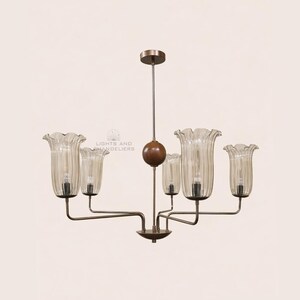 May include: A vintage-style chandelier with six lights. The fixture has a bronze finish with clear, ribbed glass shades shaped like flowers. The central stem features a wooden sphere. The image includes the text "LIGHTS AND CHANDELIERS".