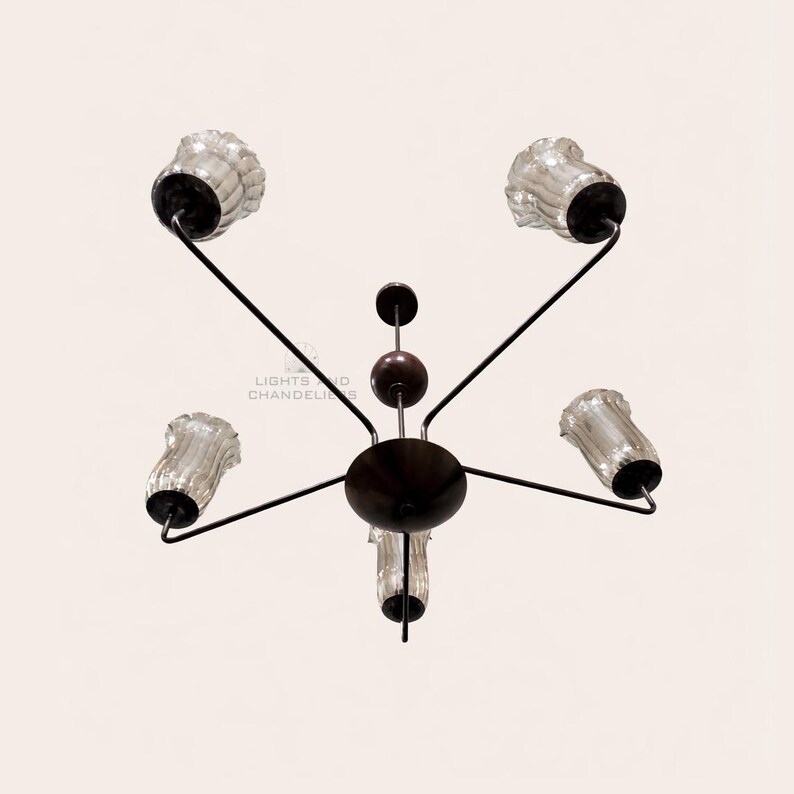 May include: A dark brown chandelier with five clear glass shades. The fixture has a central circular base with arms extending to hold the shades. The text "LIGHTS AND CHANDELIERS" is visible.