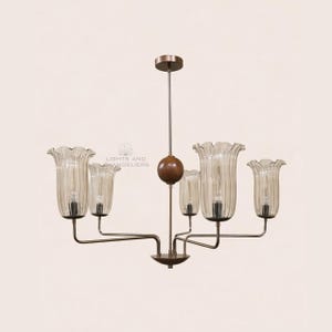 May include: A vintage-style chandelier with six light fixtures. The chandelier features clear, ribbed glass shades shaped like flowers, suspended from a bronze-colored metal frame. A wooden sphere and a central rod support the lights. The text "LIGHTS AND CHANDELIERS" is visible.