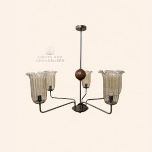 May include: A vintage chandelier with five glass shades. The shades are shaped like flowers and have a ribbed texture. The metal frame is dark, and the fixture hangs from a central rod. The text "LIGHTS AND CHANDELIERS" is in the image.
