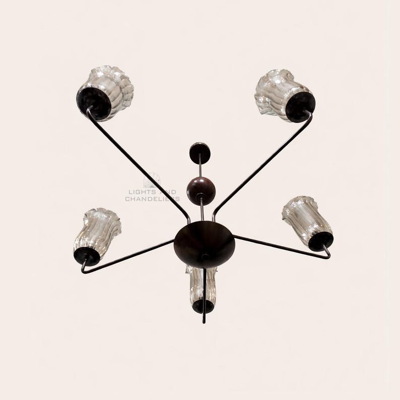May include: A dark brown chandelier with five clear glass shades. The fixture has a central circular base with arms extending to hold the shades. The text "LIGHTS AND CHANDELIERS" is visible.