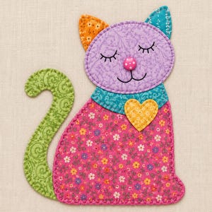 Puede incluir: Una aplicación de tela con forma de gato que presenta una cabeza lavanda con ojos cerrados bordados, una nariz de botón rosa con lunares y una cola verde curva. El cuerpo es de tela floral rosa con un parche de corazón amarillo y un collar azul.