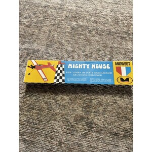 May include: A rectangular box for a Mighty Mouse 10-3/16 inch control line sport and mouse class racer for .049 radial mount engines. The box features a red airplane illustration, a black and white checkered pattern, and the Midwest logo.