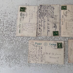 Pode incluir: Quatro postais antigos com mensagens escritas &agrave; m&atilde;o. Os postais s&atilde;o de cor creme com tinta verde e preta. Os postais t&ecirc;m selos do in&iacute;cio do s&eacute;culo XX.