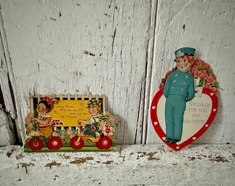 Antico set meccanico di due San Valentino degli anni '30 con bambini su triciclo, postino con fiori