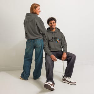 May include: Two people wearing grey hoodies and jeans. The hoodie on the right has the text "BAD WORKFLOW MERCH" in black, with colourful accents. The person on the right is sitting on a white chair.