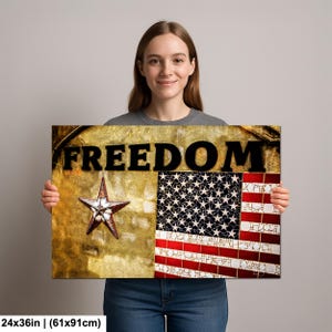 Puede incluir: Impresión rectangular en lienzo con la palabra "FREEDOM" en letras negras en negrita. La obra presenta una estrella y una sección de la bandera americana. La impresión mide 61x91cm.