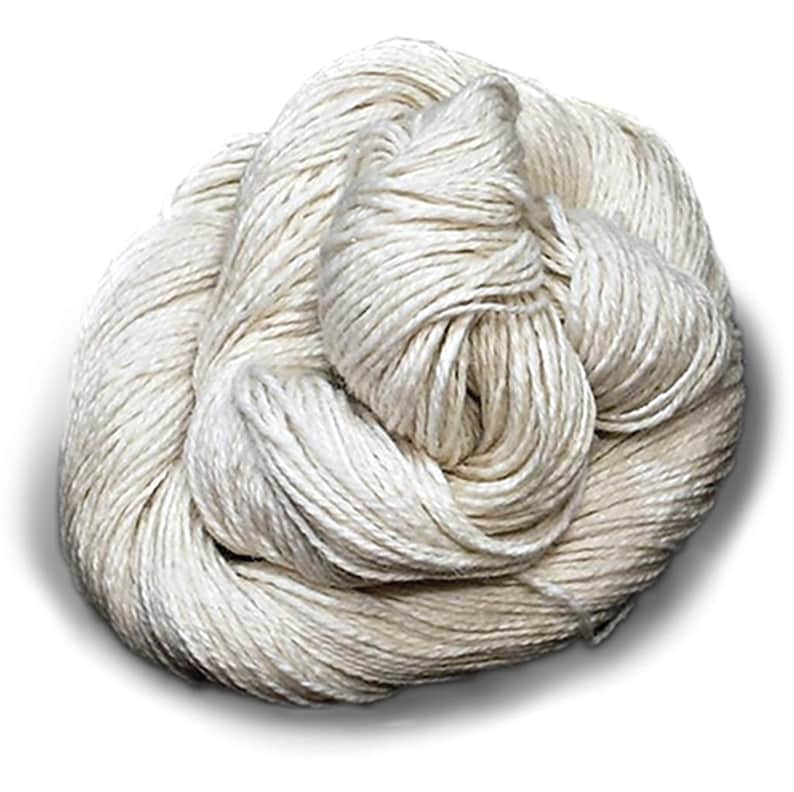 Puede incluir: Una madeja de hilo color blanco roto enrollada en un paquete suelto y retorcido. El hilo presenta una textura suave y ligeramente lustrosa con hebras individuales visibles retorcidas para formar una fibra continua de color natural.