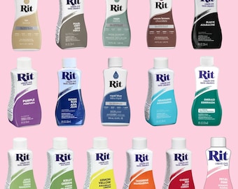 May include: Assortment of Rit liquid dye bottles in various colors, including tan, pearl grey, sage, cocoa brown, black, purple, denim blue, royal blue, aquamarine, emerald, apple green, kelly green, lemon yellow, tangerine, cherry red, and petal pink. Each bottle is labeled with the color name and the Rit brand logo.