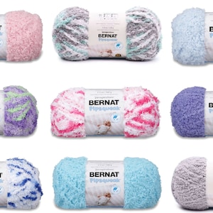 May include: Nine skeins of Bernat Pipsqueak yarn in various colors, including pink, blue, purple, and green. Each skein has a white fluffy texture and a striped pattern.