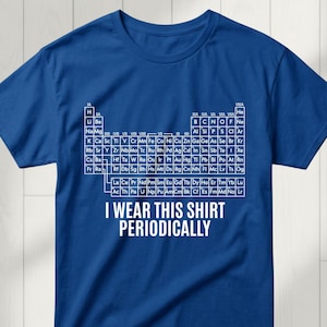 Può includere: T-shirt blu con la tavola periodica degli elementi bianca. Il testo « I WEAR THIS SHIRT PERIODICALLY » è stampato sotto. Una t-shirt a tema scientifico.