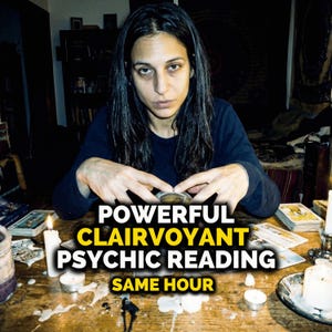 May include: A person with dark hair sits at a wooden table, with the text "POWERFUL CLAIRVOYANT PSYCHIC READING SAME HOUR" overlaid. Tarot cards and candles are present, creating a mystical atmosphere. The image suggests a psychic reading service.