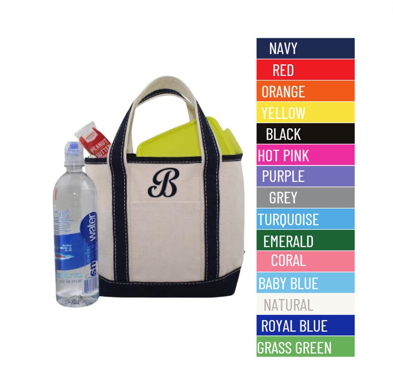 May include: A white canvas tote bag with navy blue trim and a navy blue embroidered letter "B". The bag is filled with a water bottle and a peanut butter packet. The image also shows a color chart with various colors, including navy, red, orange, yellow, black, hot pink, purple, grey, turquoise, emerald, coral, baby blue, natural, royal blue, and grass green.