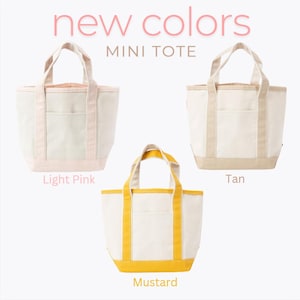 以下が含まれることがあります： 薄いピンク、タン、マスタードイエローの3色のミニトートバッグ。バッグはキャンバス製で、前面にポケットが1つ付いたシンプルなデザイン。バッグの上に「new colors MINI TOTE」の文字が表示されています。