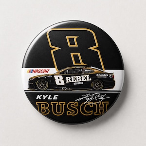 Peut inclure: Un bouton noir et doré avec une voiture de course portant le numéro 8 et le mot "REBEL" sur le côté. Le bouton comprend également le texte "KYLE BUSCH" et une signature.