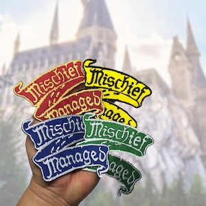 May include: A collection of embroidered patches in various colours, including red, yellow, blue, and green. Each patch features the words "Mischief Managed" in a decorative font, with gold or white trim.
