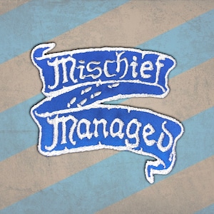 Peut inclure: Un &eacute;cusson brod&eacute; bleu avec les mots "Mischief Managed" en &eacute;criture blanche. L'&eacute;cusson a la forme de deux banni&egrave;res superpos&eacute;es. Le fond est un motif &agrave; rayures diagonales bleues et beiges.
