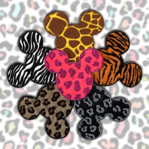 Peut inclure: Collection de patchs brodés en forme de tête de souris, avec différents motifs d'imprimés animaliers. Les patchs comprennent des imprimés zèbre, girafe, tigre, léopard et guépard aux couleurs vives.