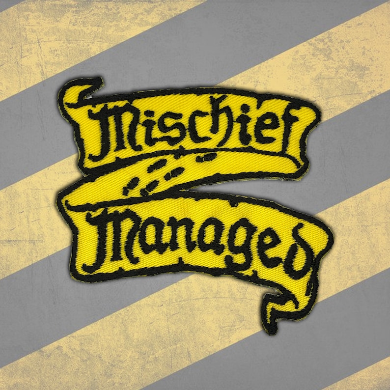 Peut inclure: Un &eacute;cusson brod&eacute; jaune avec les mots "Mischief Managed" en &eacute;criture noire. L'&eacute;cusson a un design de banni&egrave;re avec un fond vieilli de rayures diagonales grises et jaunes. L'&eacute;cusson pr&eacute;sente un motif de petites empreintes de pas.