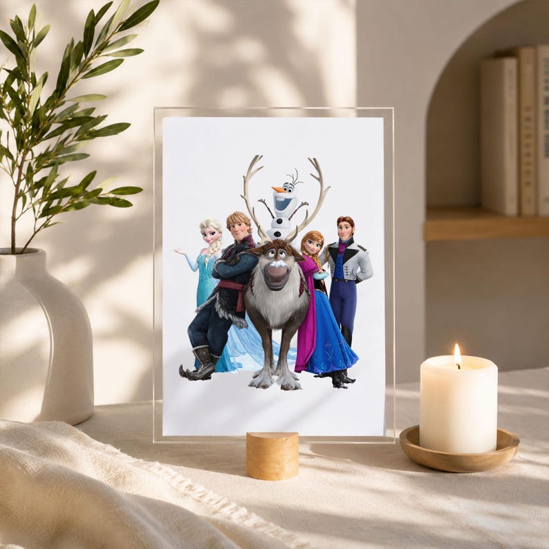 May include: A rectangular acrylic frame displays a printed illustration of the characters Elsa, Kristoff, Sven the reindeer, Olaf the snowman, Anna, and Hans standing together against a plain white background in a group portrait composition.