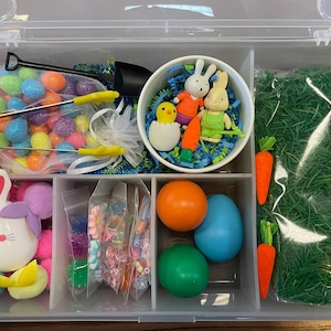 May include: A white ceramic mug with a black handle and the text "But First, Coffee" in a black, handwritten-style font. The mug is on a white surface.