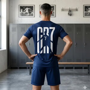May include: A dark blue athletic jersey and matching shorts set. The back of the jersey features a large white graphic with the text CR7, incorporating a silhouette of a soccer player with the number 7 centered within the design.