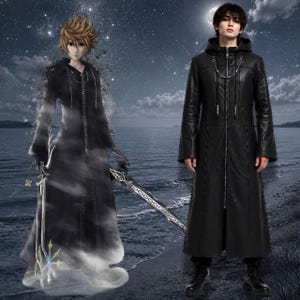 May include: A long black hooded coat featuring a full-length front zipper, a silver chain detail across the chest, and long sleeves. The coat has a structured collar and a smooth finish, extending down to the mid-calf area with a straight hemline.