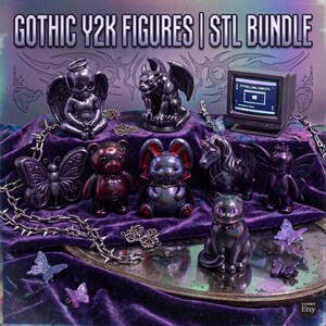 May include: A collection of dark-toned figures including a winged skull, gargoyle, butterfly, bear, rabbit, unicorn, fairy, and cat, plus a miniature computer monitor displaying text. A spiked chain and small butterfly accents are included.