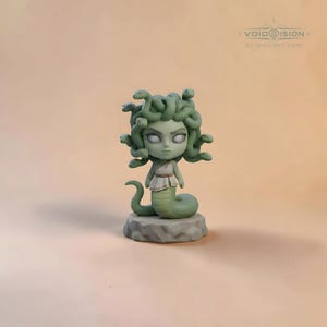 May include: A green Medusa figurine with snake hair, a white tunic, and a snake tail, standing on a gray stone base. The figurine has a stern expression and is a stylized representation of the mythological figure. The text "VOID VISION" is visible.