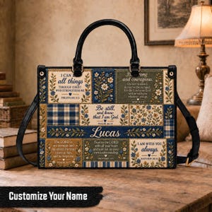 Peut inclure: Un sac à main rectangulaire avec des poignées et des bordures en cuir noir, présentant un motif patchwork de fleurs bleues, crème et vertes. Le sac affiche des textes religieux dont Philippians 4:13, Joshua 1:9, Psalm 46:10 et le nom Lucas.
