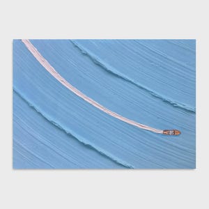 May include: A small wooden boat with a brown hull travels across a textured light blue surface, leaving a long, curved white wake behind it. The background consists of thick, diagonal paint strokes in varying shades of light blue.