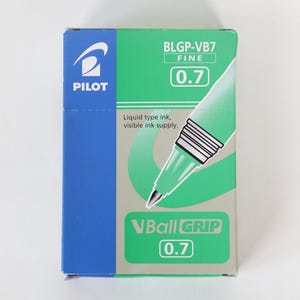 May include: A box of Pilot VBall Grip pens. The packaging is green and blue, with the Pilot logo and pen details. The text on the box reads "BLGP-VB7 FINE 0.7" and "VBall GRIP 0.7". The packaging indicates liquid type ink and visible ink supply.