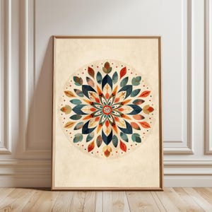 Può includere: Una stampa artistica incorniciata con un design mandala colorato. Il mandala è composto da foglie stilizzate nei toni del blu, arancione, rosso e verde, disposte in un motivo circolare su uno sfondo color crema. La cornice è in legno.