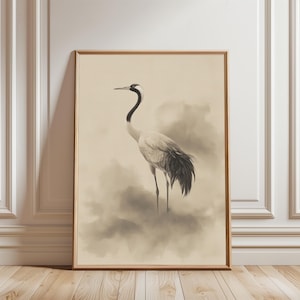 Op de afbeelding: Ingelijste kunstafdruk in sepia-tinten, met een kraanvogel. De kraanvogel heeft een wit lichaam, een zwarte nek en staartveren en staat in een mistige, wolkenachtige omgeving. Het kunstwerk is ingelijst in een eenvoudige houten lijst.