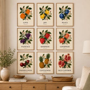 May include: A set of nine rectangular wall art prints featuring botanical illustrations of fruits including oranges, lemons, blueberries, grapes, strawberries, peaches, cherries, pineapples, and pomegranates, each labeled with a virtue and text.