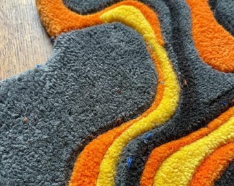 Alfombra Magma Flow tejida a mano, arte abstracto de lava, color amarillo carbón anaranjado.