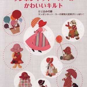 Op de afbeelding: Een boekomslag met Japanse tekst, waaronder "サンボンネット・スーの かわいいキルト". Het toont stoffen poppenontwerpen, zoals figuren met hoeden, paraplu's en ballonnen, tegen een lichte achtergrond, met een stippenpatroon.