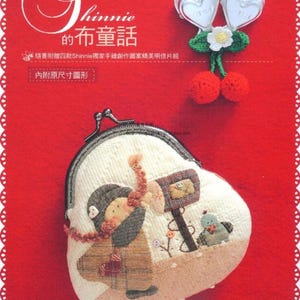 May include: A red background with a white lace border features a fabric purse with a whimsical design. The purse depicts a character with a scarf and hat, holding a mailbox. The text "Shinnie's quilt Child's talk" is visible.