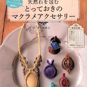 Può includere: Copertina di un libro con gioielli macramè fatti a mano con pietre naturali. La copertina, con testo giapponese, mostra una collana, anelli e pendenti in vari colori, tra cui giallo, marrone, blu, viola e rosso.