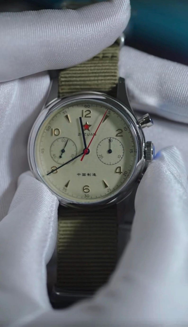 May include: A vintage-style wristwatch with a cream-colored face, black hands, and red second hand. The watch features a stainless steel case and a green nylon strap. The face includes the text "ZIZUAN" and "中国制造".
