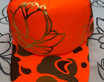 A neon orange camo trucker with gold lotus