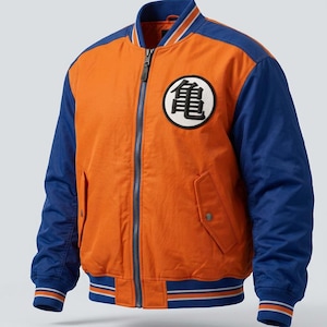 May include: An orange and blue bomber jacket featuring a full-length front zipper, ribbed collar, cuffs, and hem with striped detailing. A circular white patch with a black Japanese kanji character is displayed on the left chest area.