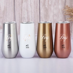 Peut inclure: Quatre flûtes à champagne sans pied argentées, blanches, dorées et or rose. Chaque gobelet porte l'inscription "Joy", une croix, un croissant de lune et le texte "Flower Sun Love".