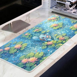 Op de afbeelding: Een rechthoekige muismat met een serene vijverscène met waterlelies en een cartoon schildpad karakter. De mat heeft een blauwe waterachtergrond met roze en gele bloemen en groene waterlelies.