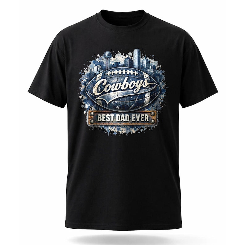 May include: Black t-shirt featuring a football design with the word "Cowboys" and a cityscape graphic. Below the football is a banner that reads "BEST DAD EVER". The design is in shades of blue, white, and brown.
