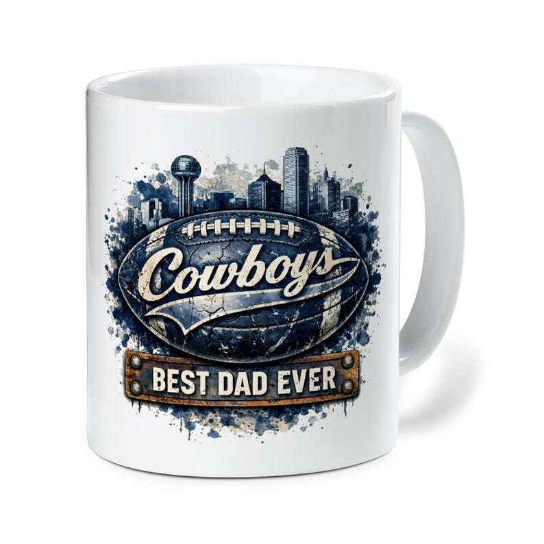 May include: White ceramic mug featuring a football design with the word "Cowboys" and a cityscape silhouette. Below the football is a rectangular plaque that reads "BEST DAD EVER".